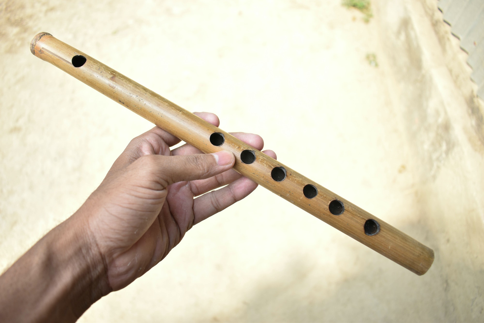 Closeup of hand holding wooden flute